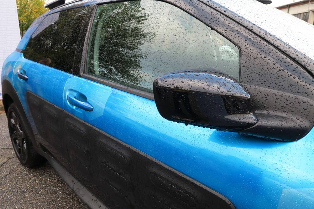 Spiegelfolie im Test: Blau-schwarzes Auto mit Spiegelfolie im hinteren Bereich.