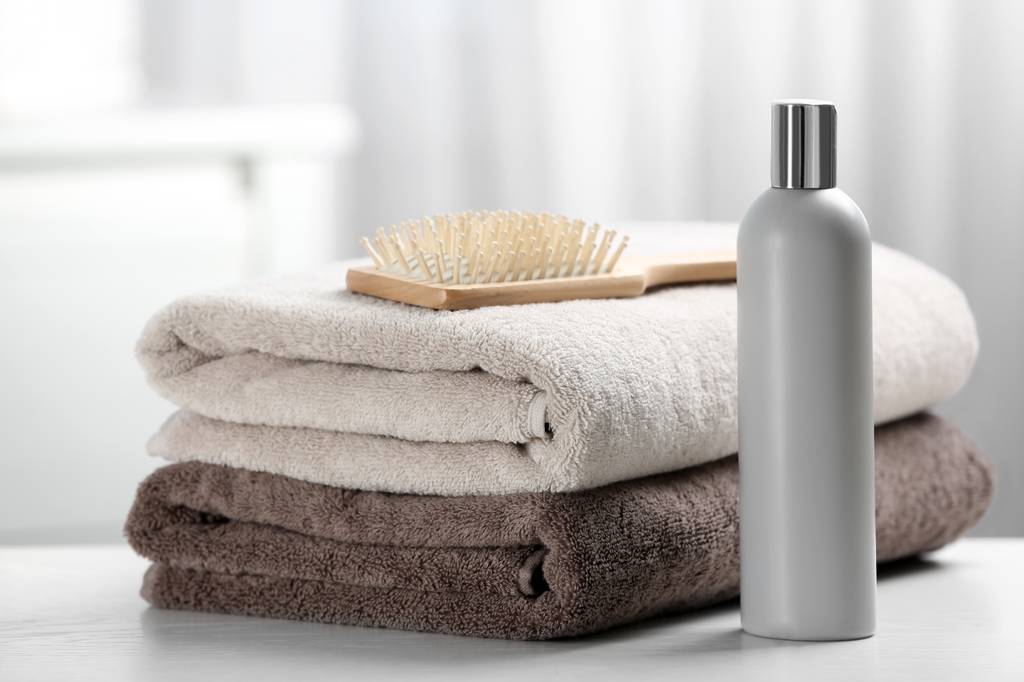 Sebastian-Shampoo-Test: Zwei Handtücher liegen aufeinander. Auf ihnen ist eine Bürste platziert und daneben steht ein Shampoo. 