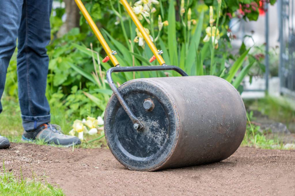 Rasenwalze im Test: Walze wird über nackte Erde – vermutlich mit Rasensamen – geschoben.