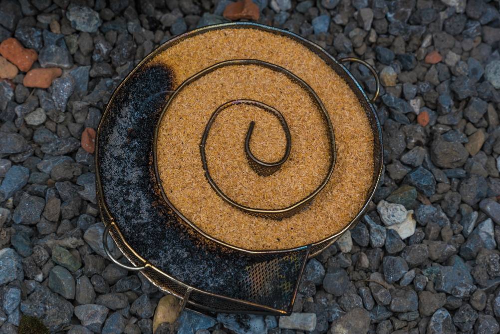 Räuchertonne im Test: Eine Räucherspirale gefüllt mit Räuchermehl – teilweise bereits abgebrannt.