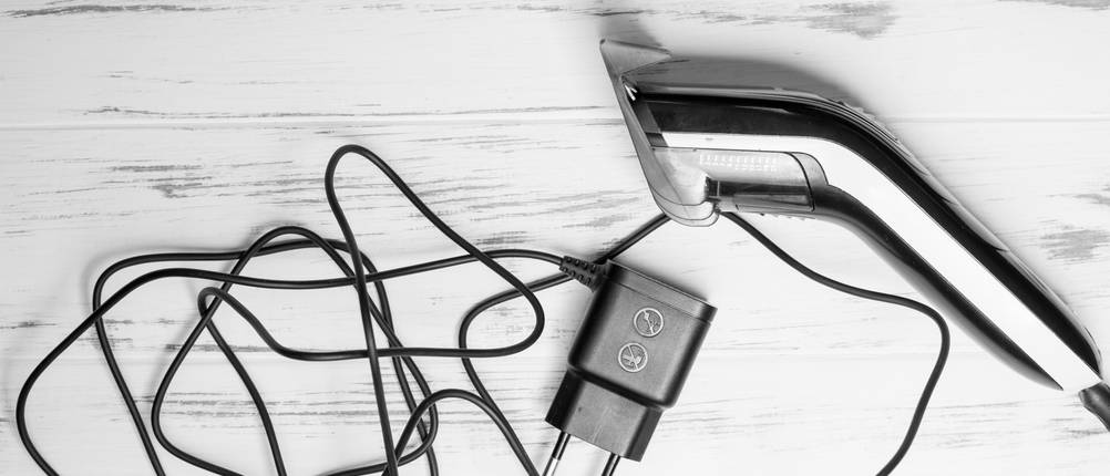 Haarschneidemaschine mit Kabel Test: Eine Haarschneidemaschine ist neben dem Ladekabel platziert.