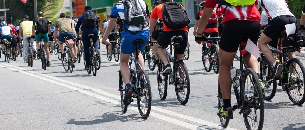 Triathlon-Rucksack-Test: Mehrere Personen fahren auf einem Fahrrad und tragen dabei Rucksäcke.