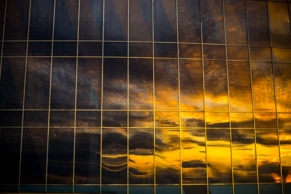 Spiegelfolie im Test: Eine komplett verspiegelte Fassade, in der sich ein Sonnenuntergang spiegelt.