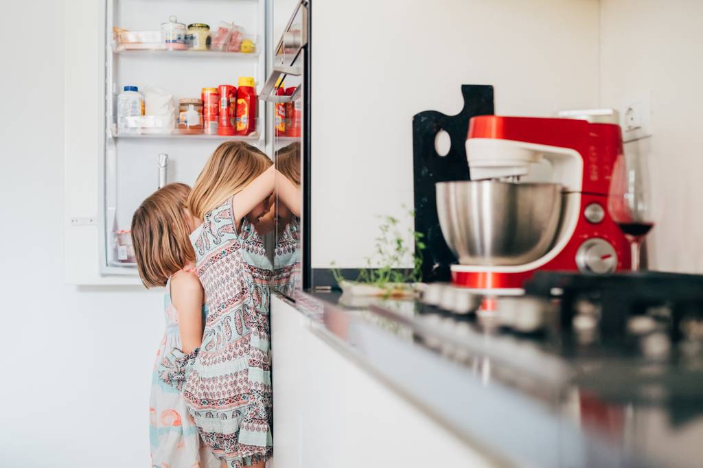 AEG-Kuehlschrank-Test: Zwei Kinder stehen suchend vor einem Kuehlschrank.
