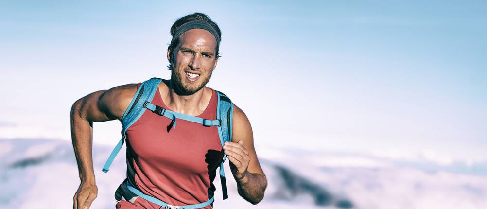 Triathlon-Rucksack-Test: Ein Mann läuft, während er dabei einen Rucsack trägt.