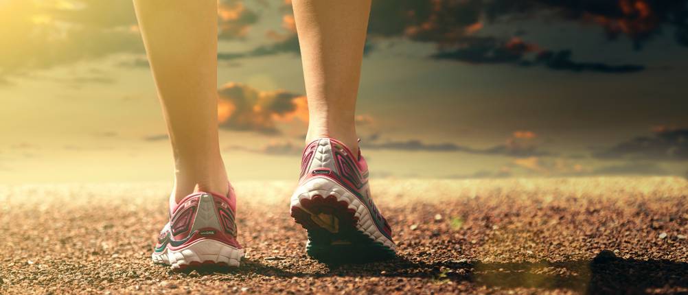 Trailrunningschuhe-Damen-Test: Eine Frau steht mit Laufschuhen auf einem unebenen Boden.