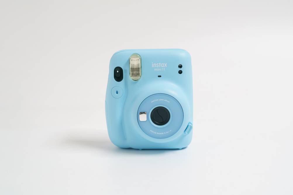 Polaroid-Kamera im Test: Eine hellblaue Instax Mini 11 vor weißem Hintergrund.