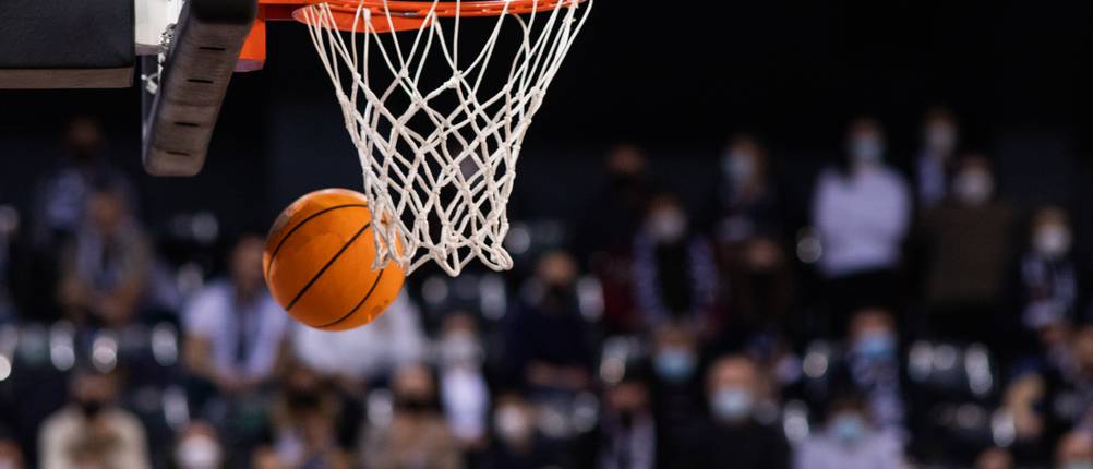 Basketballanlage-Test: Der Basketballkorb im Fokus, während ein Ball vorbeifliegt.