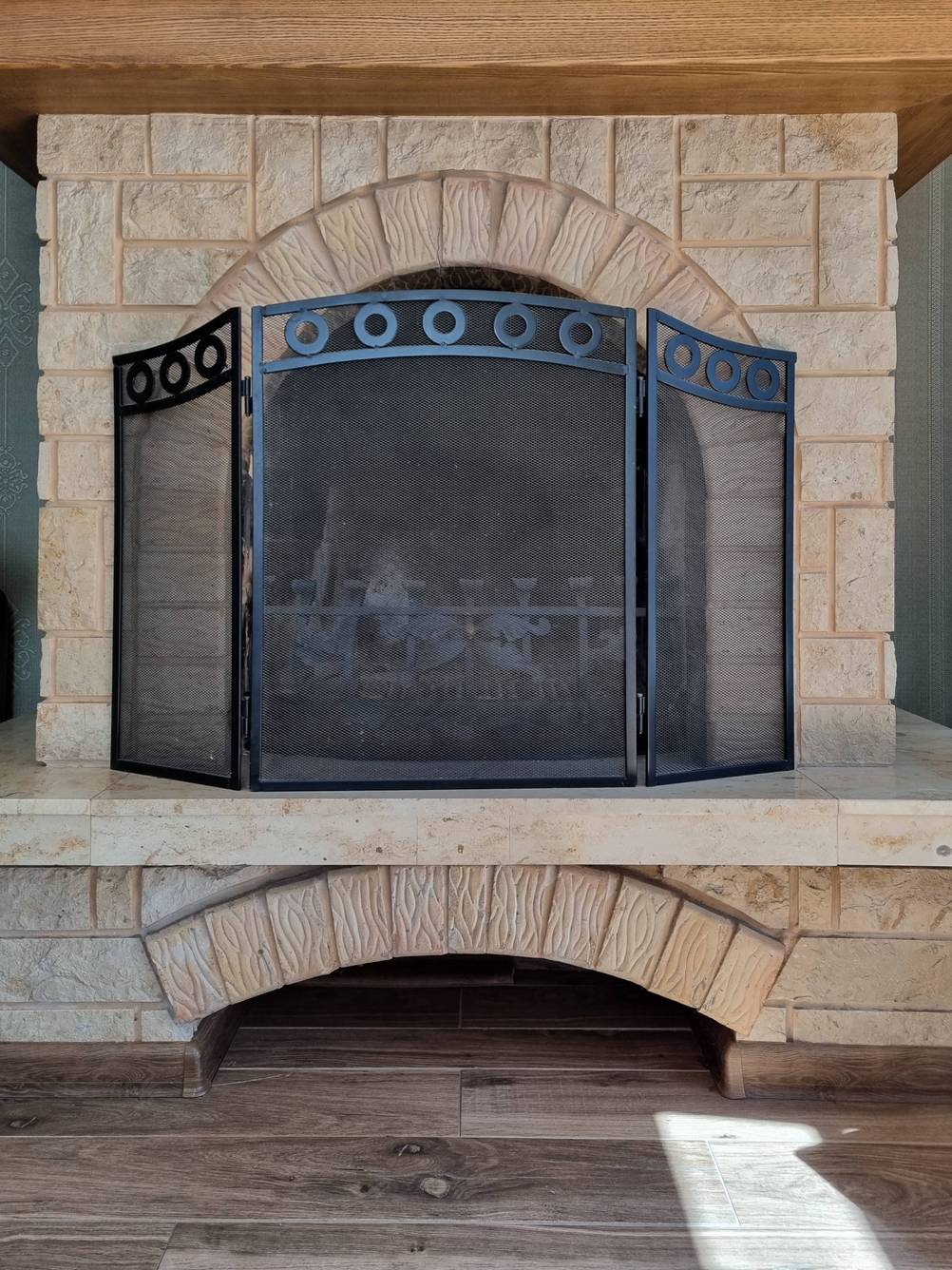 Kaminschutzgitter im Test: Schutzgitter in schwarz vor gemauertem offenem Kamin ohne Feuer