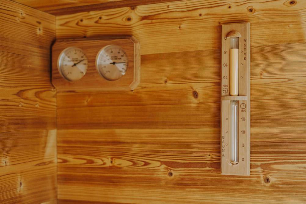 Sauna-Thermometer im Test: Thermometer, Hygrometer und Sanduhr aus Holz.