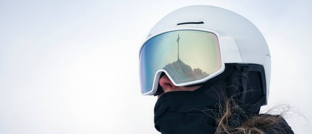 Black-Crevice-Skihelm-Test: Eine Frau trägt einen weißen Skihelm mit einer Skibrille.