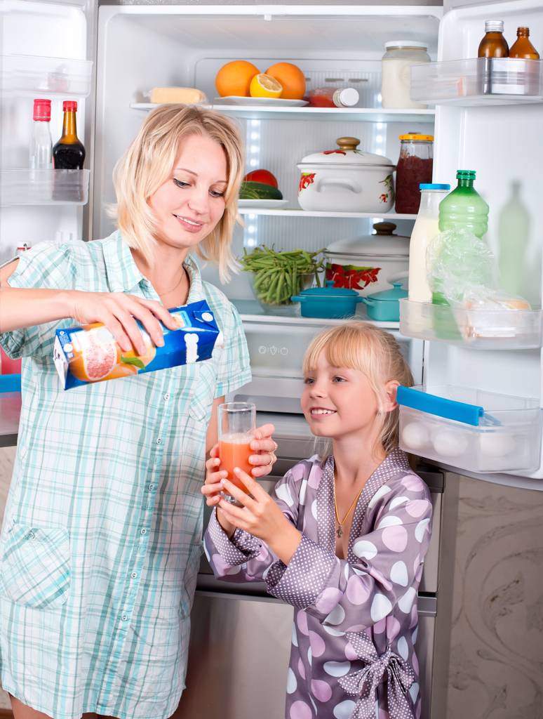 Haier-Side-by-Side-Test: Eine Frau und ein Kind stehen vor einem offenen Kühlschrank.