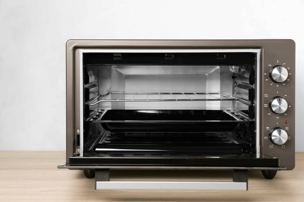 Mini-Backofen 45 Liter im Test: offenes Gerät mit drei Drehknöpfen, Rost und Backblech.