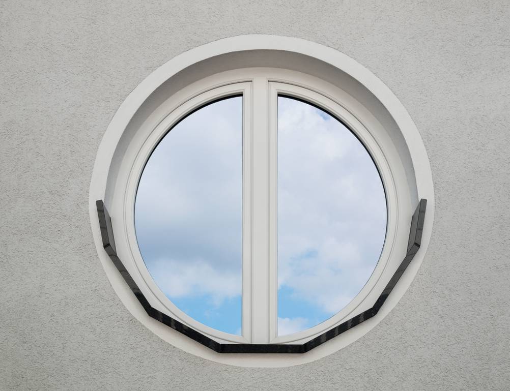Spiegelfolie im Test: Modernes Bullauge aus PVC mit Spiegelfolie in grauer Fassade.