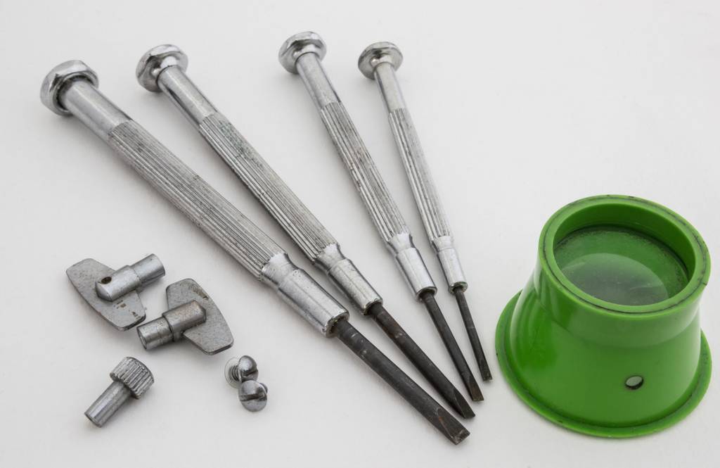 Schraubendreher im Test: Ein Feinmechaniker-Schraubendreher-Set mit Lupe und kleinen Schrauben bzw. Schlüsseln.