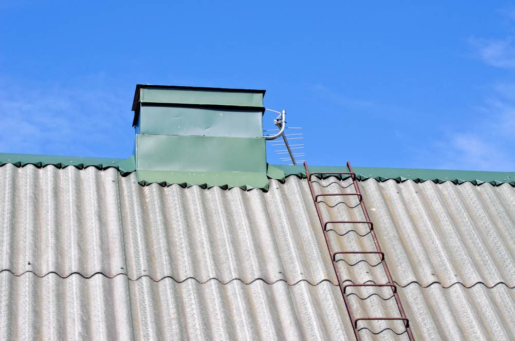 Dachleiter-Test: Eine Stahlleiter auf einem Welldach, die sichtlich korrodiert ist.