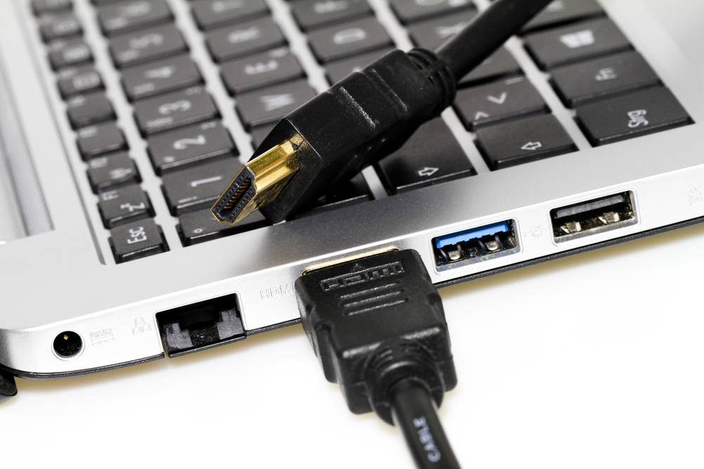 HDMI-Kabel im Test: Vergoldeter Anschluss eines HDMI-Kabels auf einer Laptop-Tastatur zu sehen.