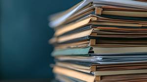 Buchhaltungssoftware im Vergleich: Ein Stapel Akten vor blauem Hintergrund.