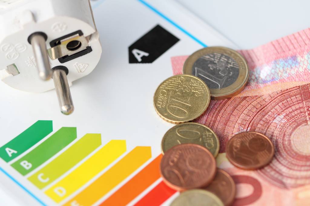 Haier-Gefrierschrank im Test: Stecker, Energieklassen und Geldschein sowie Münzen.