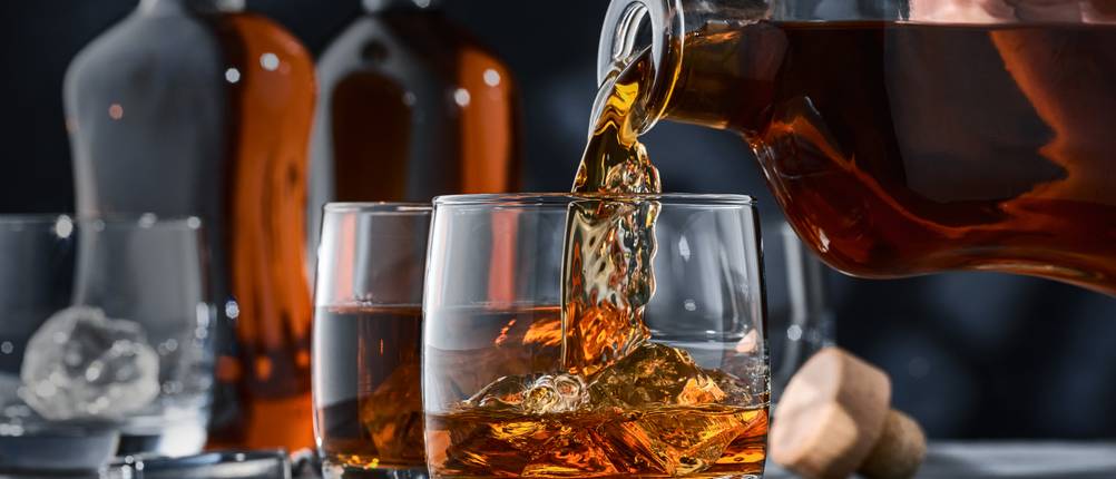 Whisky-Karaffe getestet: jemand füllt Whisky aus einer Karaffe in ein Glas