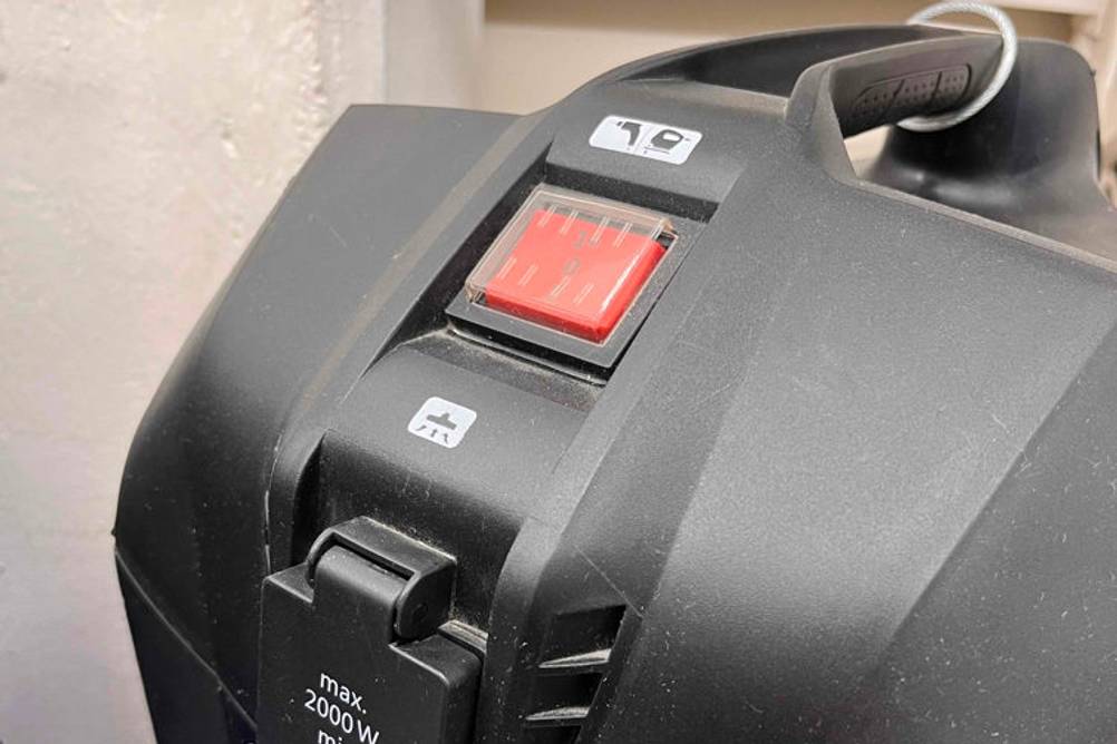 Nahaufnahme von oben eines Bosch-Staubsaugers im Test: Deckelbereich des Modells AdvancedVac 20 Autostart mit integrierter Steckdose.