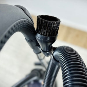 Detailaufnahme der runden Bürstendüse am Schlauch des AEG Clean 6000 ÖKO. Die Borsten sind weich und dicht angeordnet.