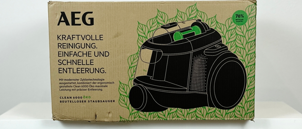 Die Verpackung des AEG Clean 6000 ÖKO zeigt das Produktbild und Hinweise zur einfachen Entleerung. Der Öko-Hinweis ist deutlich erkennbar.