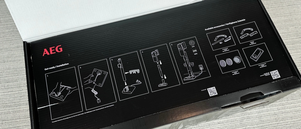 Die geöffnete Verpackung des AEG AP81AB25UG zeigt eine grafische Aufbauanleitung auf der Innenseite des Deckels.