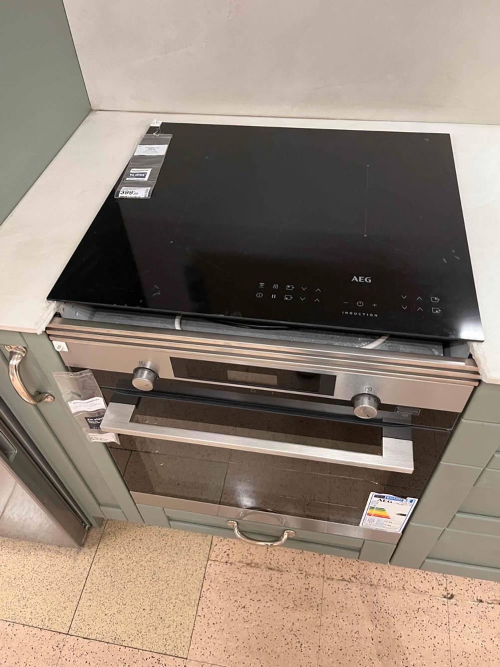 Ansicht von oben auf einen eingebauten und getesteten AEG-Backofen sowie auf eine AEG-Kochplatte.