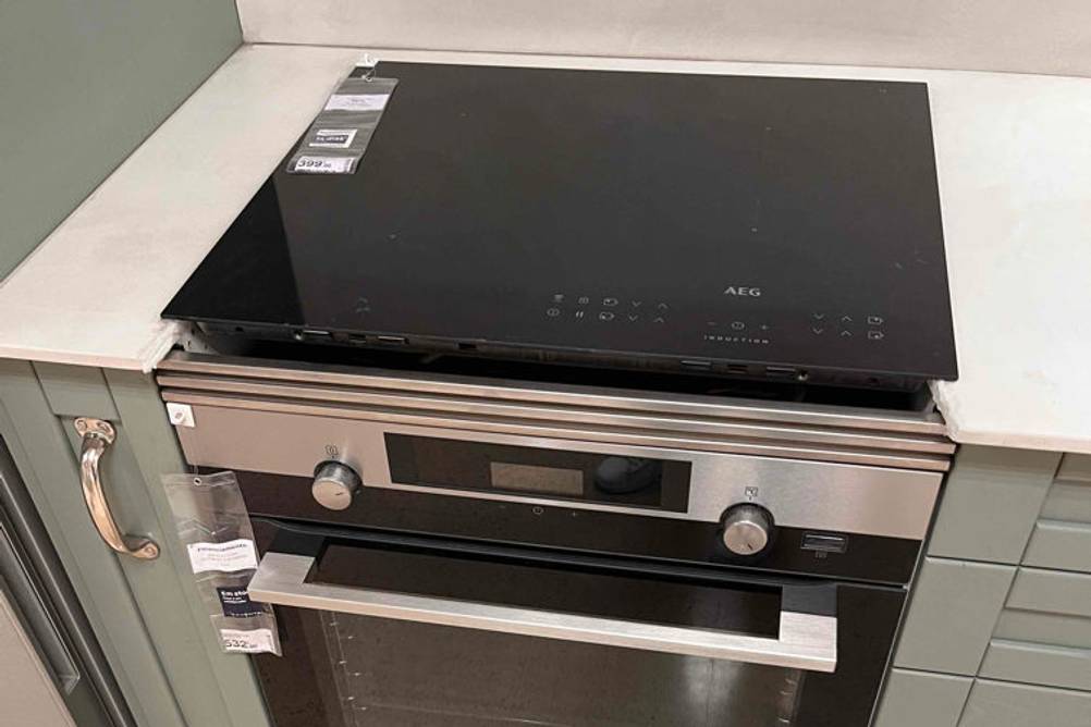 AEG-Backofen im Test: Ein Einbaubackofen inklusive eines breiten Edelstahl-Griffs befindet sich in einer Küchenzeile.