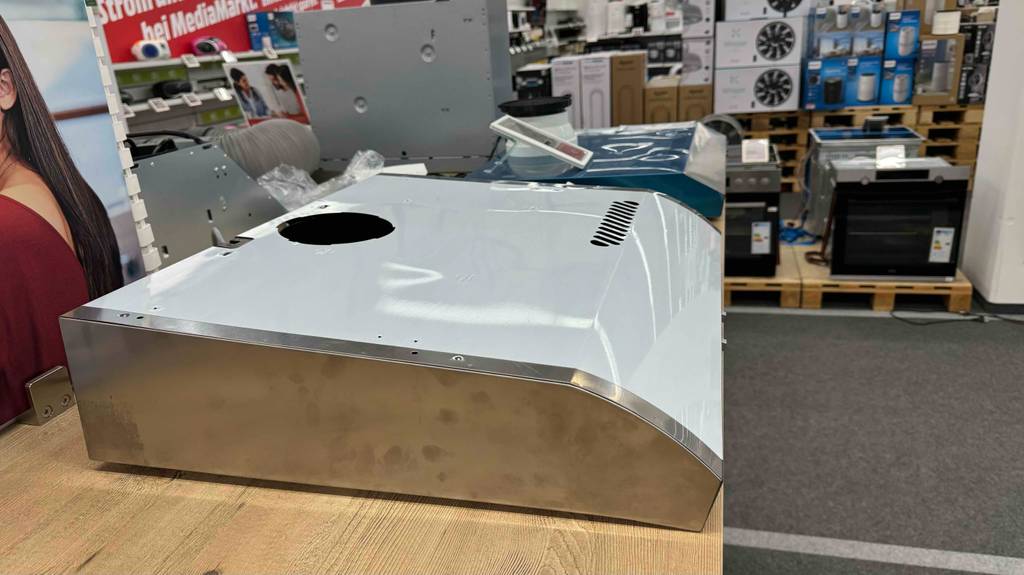 Seitenansicht einer Dunstabzugshaube Unterbau, die zum Testen auf einem Holztisch liegt.