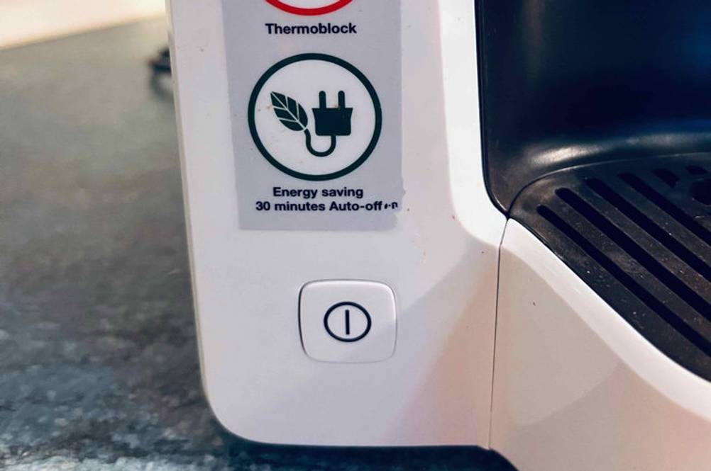 Kaffeemaschine-Test: Detailansicht der Einschalttaste einer weißen Kaffeemaschine mit Thermoblock.