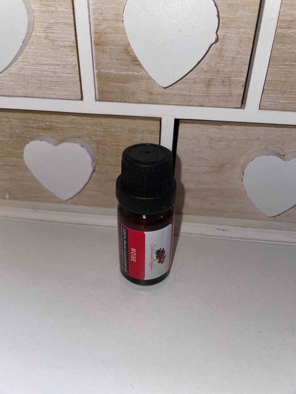 Ätherische Öle getestet: Eine Flasche mit Duftrichtung Rose vor einem kleinen Holzkästchen.