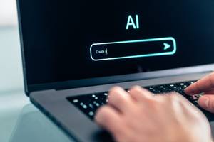 KI-Text-Generatoren getestet: Eine Person tippt einen Befehl in ein KI-Tool ein.