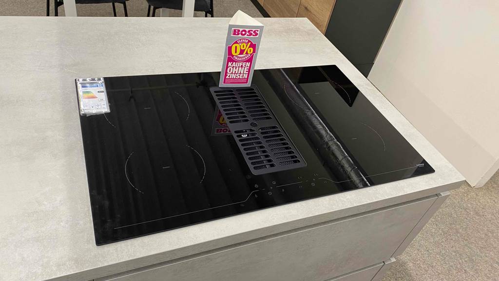 Ansicht von oben auf ein im Geschäft ausgestelltes Induktionskochfeld mit Dunstabzug im Test.