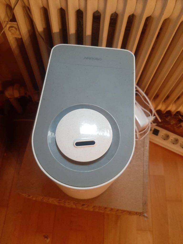 Luftbefeuchter-Test: Ansicht von oben auf einen Zerstäuber, der über einen grauen Deckel verfügt und in einem Wohnraum steht.