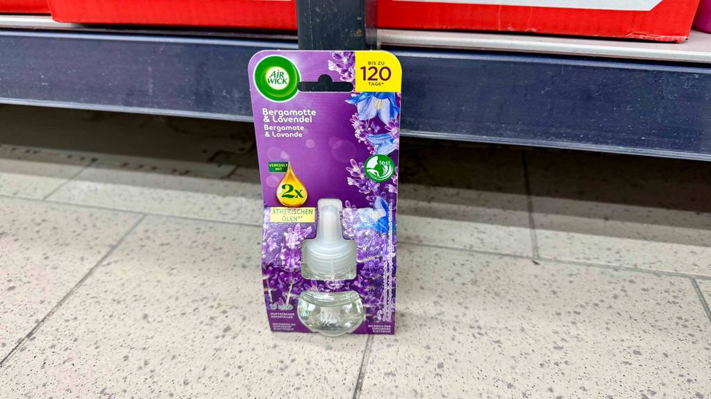 Ein getesteter Duftstecker von Airwick steht innerhalb der Verpackung vor einem Verkaufsregal.