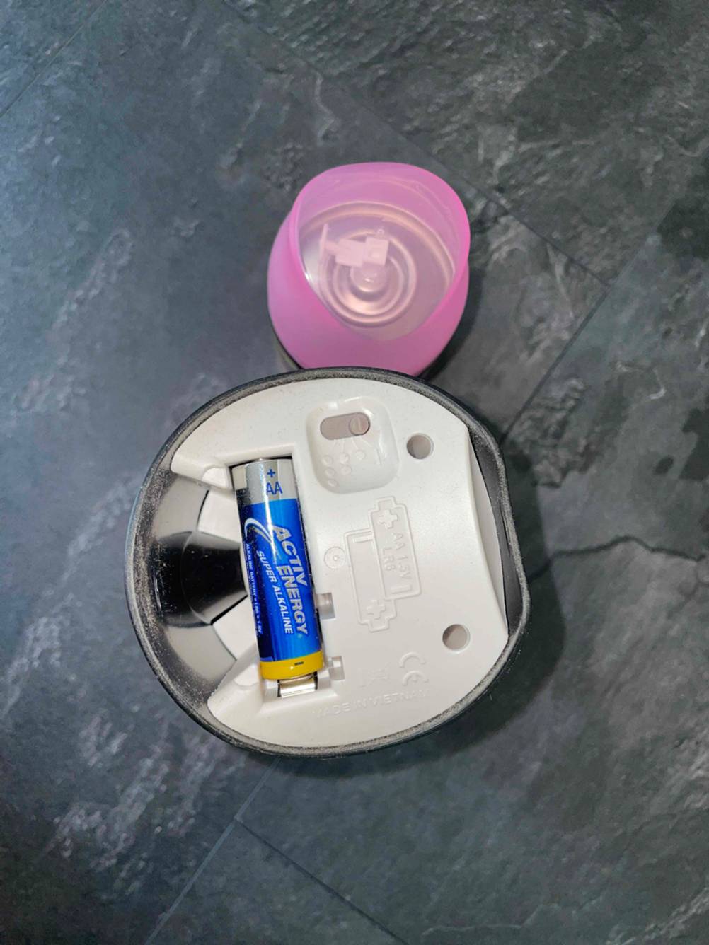 Airwick-Sprühbehälter mit offenem Batteriefach.