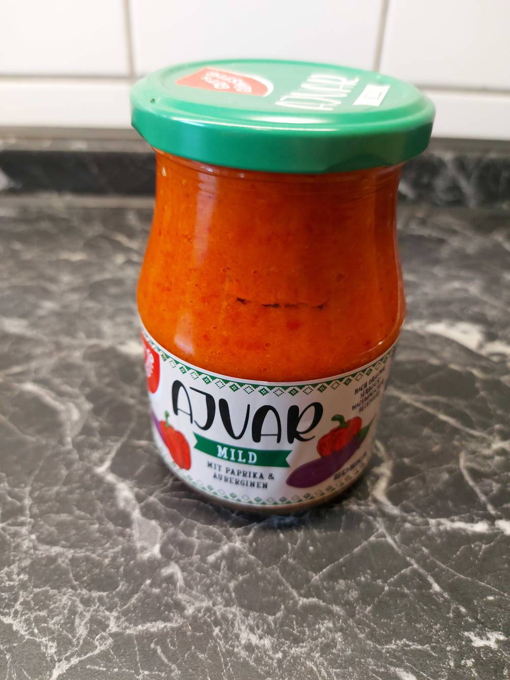 Im Test: Ein Glas Ajvar von vorne auf einer Arbeitsplatte.
