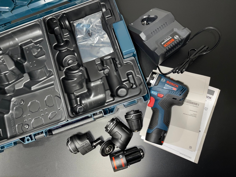 Der Bosch GSR 12V-35 FC liegt vollständig ausgepackt in seinem L-BOXX-Systemkoffer mit allen FlexiClick-Aufsätzen, zwei Akkus, Ladegerät und Dokumentation. Die übersichtliche Innenaufteilung zeigt das komplette Lieferpaket auf einen Blick.