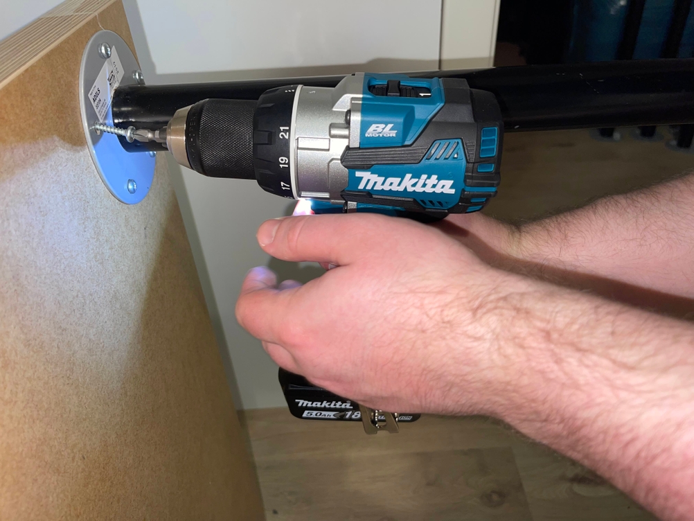 Makita Akku-Bohrschrauber im Einsatz bei der Montage eines Rohrflanschs an eine Holzplatte.