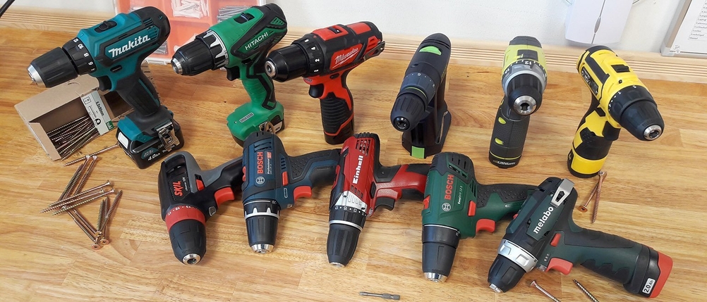 Akku-Bohrschrauber und Schrauben liegen auf einem Tisch.