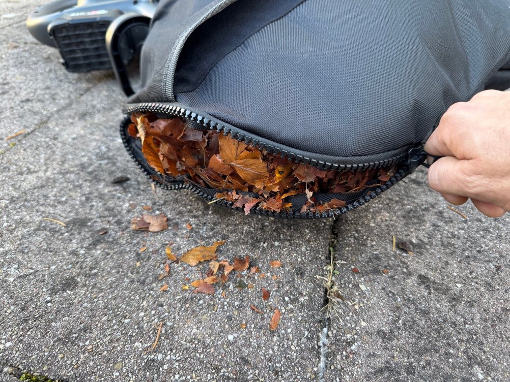 Der Reißverschluss am Fangsack des getesteten Akku-Laubsaugers von Gardena wird geöffnet.