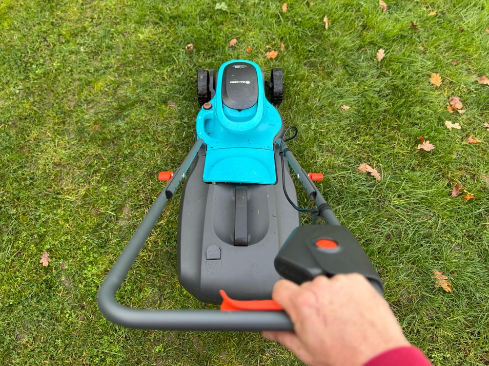 Eine Person schiebt den Gardena-Akku-Rasenmäher im Test über einen Rasen.