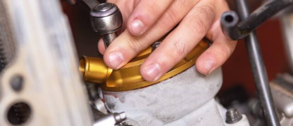 Akku-Ratsche-Test: Eine Hand hält ein Bauteil aus Messing das mit einer Ratsche bearbeitet wird.