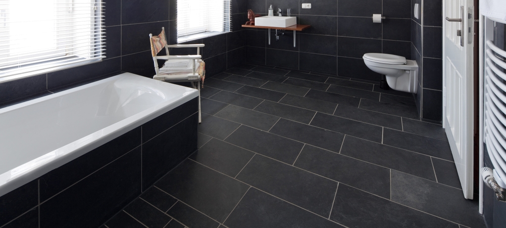 Akku-Saugwischer-Test in einem Badezimmer mit schwarzen Fliesen