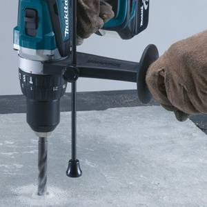 Mit einer Makita-Schlagbohrmaschine wird ein Loch in Beton gebohrt..