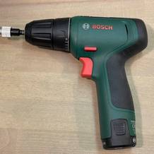 Der Bosch EasyDrill 1200 Akkuschrauber in grün-schwarzer Farbgebung auf Holzuntergrund. Das kompakte 12-Volt-Gerät zeigt deutlich die ergonomische Pistolengriff-Form.