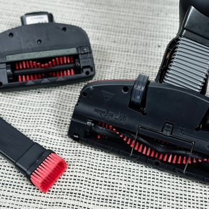 Drei Bürstenaufsätze des AEG Ergorapido CX7-2-45AN liegen nebeneinander auf einem Teppich. Die Borsten sind rot eingefärbt.