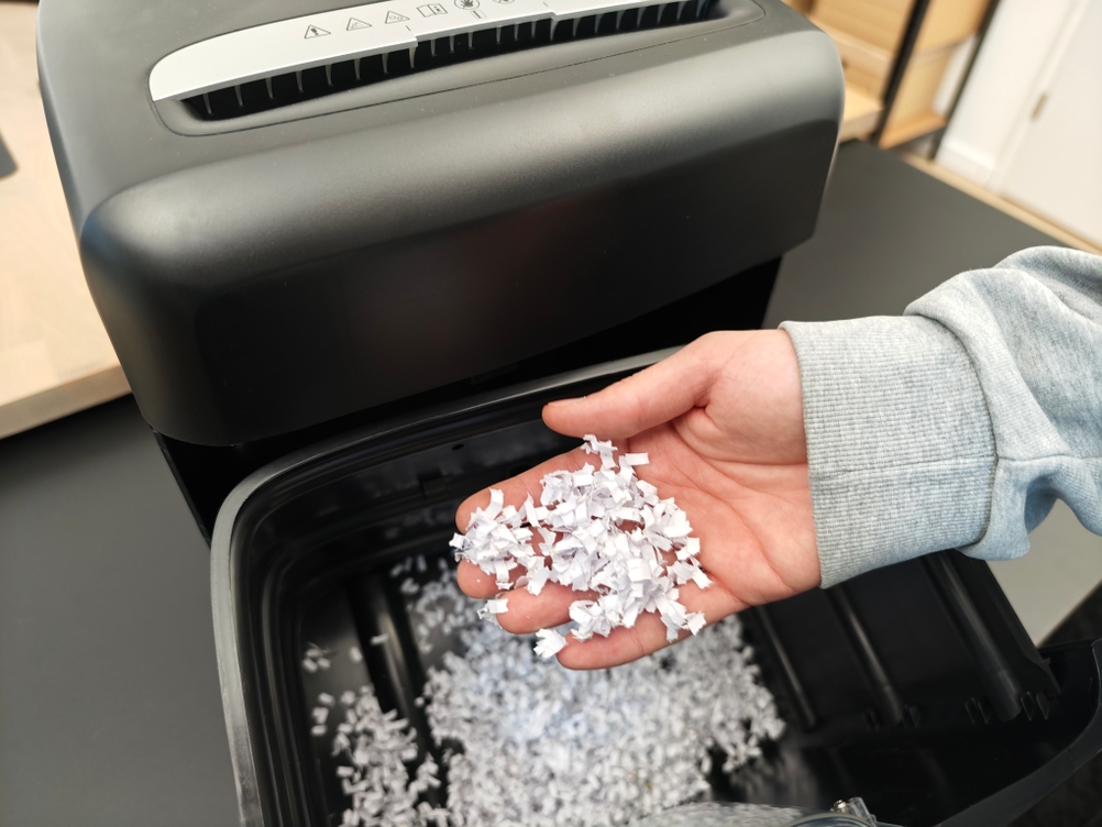Eine Person hält Schnipsel eines Amazon Basics Aktenvernichters in der Hand.